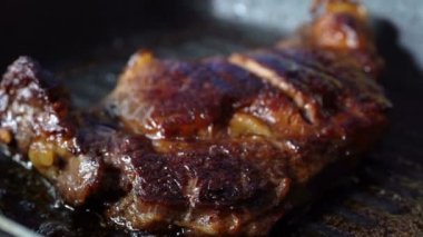 Biftek pişirmek için tavada zeytinyağıyla kızartılmış biftek.