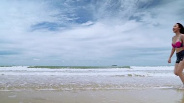 Yavaş çekim, güzel Asyalı kadınlar plaja atlıyor, özgürlük konsepti.