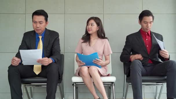 アジアの男性と女性の営業担当者は面接を待っています彼らはストレスと落ち着きを感じます彼らは欠員で仕事を必要としているので — ストック動画