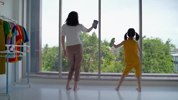 妈妈和女儿正在打扫卫生 擦玻璃 快乐地跳舞 — 图库视频影像