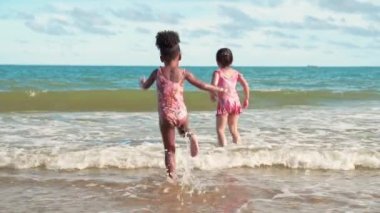 Ağır çekimde, hem Afrikalı Amerikalı hem de Asyalı kızlar suda ırkçılık yapmadan oynuyorlar..