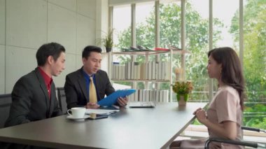 Asyalı bir kadın bir iş görüşmesi yapıyor, mülakatçıyla el sıkışıyor ve iş bulmayı bekliyor..