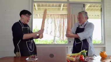 Yaşlı bir baba ve oğlu ekmek ile kılıç gibi oynuyorlar ve mutfakta eğleniyorlar..