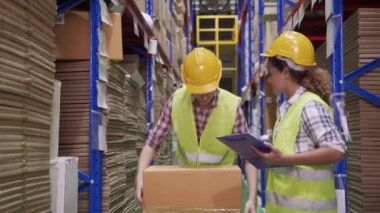 Foreman seviyesindeki işçiler barkodu tarayıp eşyaları depodaki raflara koymaya yardım ediyorlar..