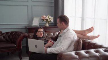 Kanepede dostça bir iş görüşmesi yapan bir çift..