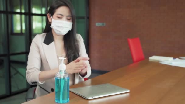 オフィスの労働者は仕事にノートパソコンを開く前に手を洗うためにアルコールジェルを使用マスクを着用 — ストック動画