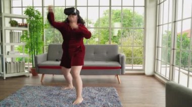 VR gözlük takan şişman Asyalı kadınlar evde egzersiz oyunları oynarlar.