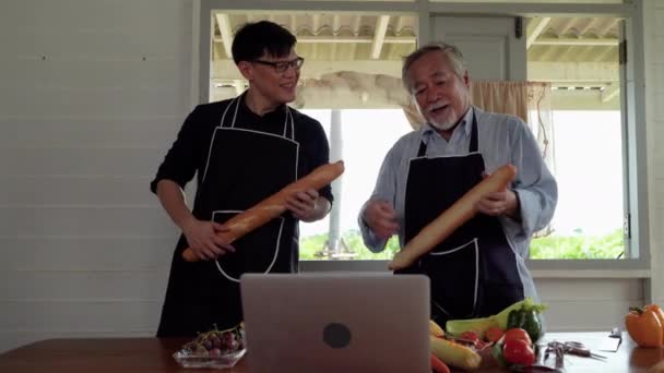 一位年迈的父亲和儿子在厨房里跳舞 带着面包做吉他手 并和他们一起歌唱 温暖的家庭 — 图库视频影像