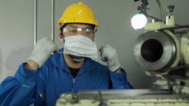 COVID 19 enfeksiyonunu önlemek için yüz maskesi takan Asyalı erkek mühendis.