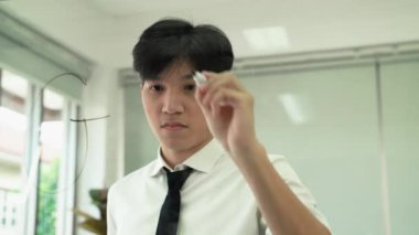 Genç bir Asyalı işadamı hedeflere ulaşma kavramını tahtaya yazar..