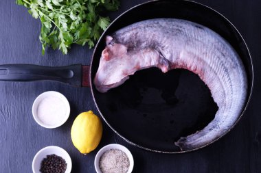 koyu ahşap bir masa hazırlama baharatlar ile taze yayın balığı balık