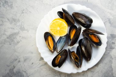 Limon gri arka plan üzerinde beyaz tabakta midye