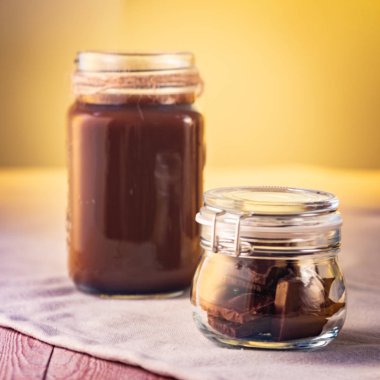 Sıcak çikolata ve çikolata kavanozun içinde. Çikolatalı tatlılar yapmak için malzemeler.