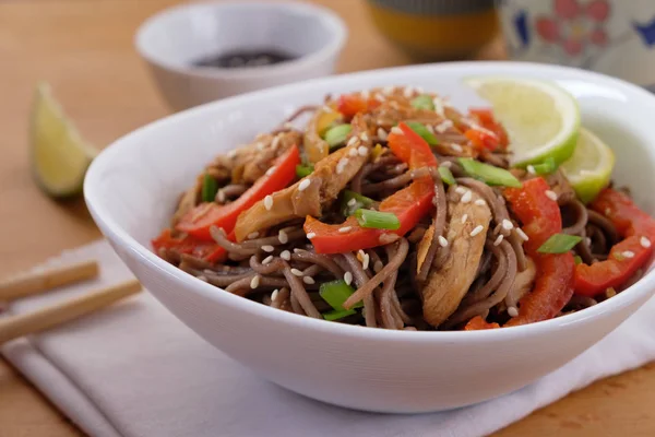 Dark pasta with steamed vegetables and grilled chicken. Selective focus.