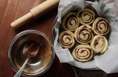 Rulo tarçın. Baharat ve parşömen kağıt üzerine doldurma kakao ile taze pişmiş tarçınlı çörek. Üstten Görünüm. Tatlı ev yapımı pasta Noel pişirme. Yakın çekim. Kanelbule - İsveç tatlı.
