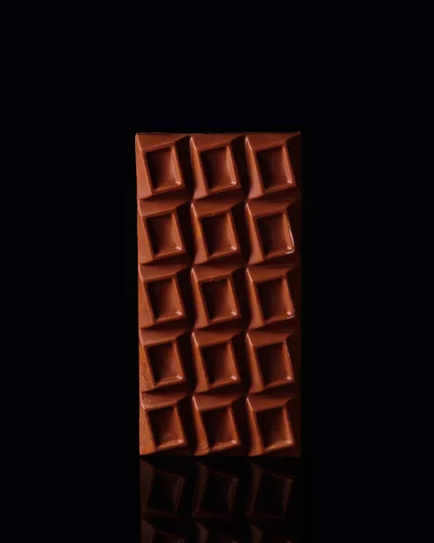 Chocolate sobre fondo negro color fruta — Foto de Stock