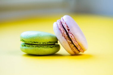 Sarı arka planda tatlı renkli badem kurabiyeleri 