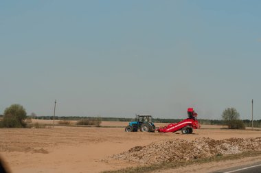 Tarlayı, toz bulutları raising kırmızı traktör 