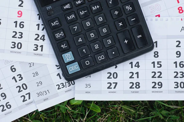 Paper sheet with text TAX DEADLINE, calculator and notebooks on wooden table