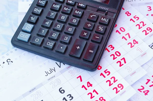 Paper sheet with text TAX DEADLINE, calculator and notebooks on wooden table