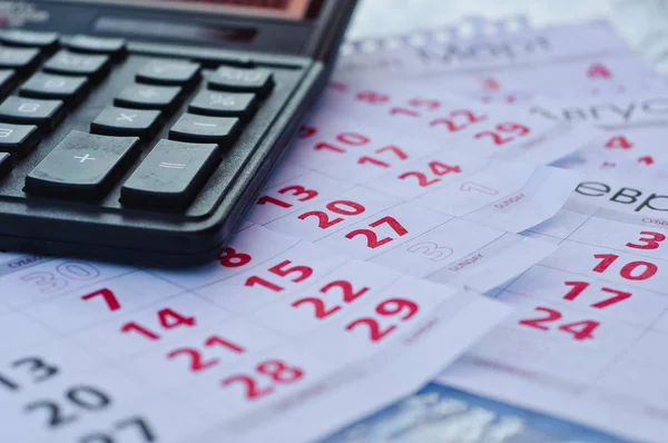 Paper sheet with text TAX DEADLINE, calculator and notebooks on wooden table