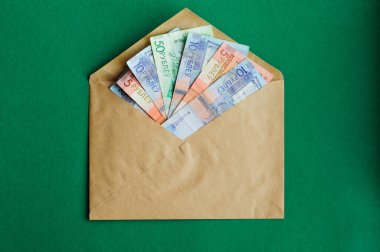 Parlak kırmızı bir zarf içinde para, renk arkaplan izole.