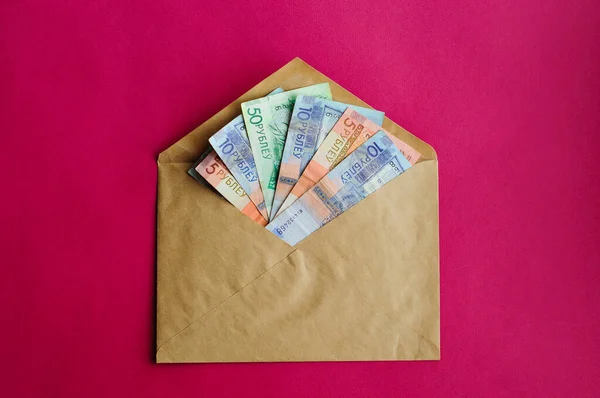 Parlak kırmızı bir zarf içinde para, renk arkaplan izole.