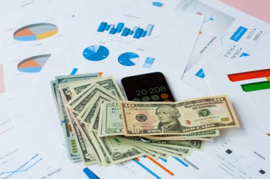 Finansal tabloların arka planında bir sürü para ve dolarımız var. Doğal fotoğraf..
