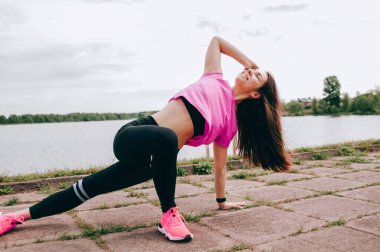 Genç, güzel bir atlet kız koşuyor. Güzel kız sporcu koşu yapıyor. Sabah koşusu. sağlıklı spor yaşam tarzı konsepti. Gri kazaklı ve siyah taytlı genç kız spor için içeri giriyor.