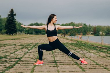 Açık havada mavi duvarda poz veren güzel fitness kızı, fotokopi alanı. Mükemmel vücutlu, sağlıklı yaşam tarzı ve vücut bakım konsepti olan sportif bir kadın.