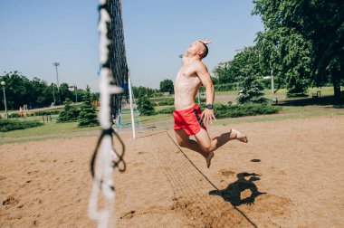 Plaj voleybolcusu topa vurmak üzere.