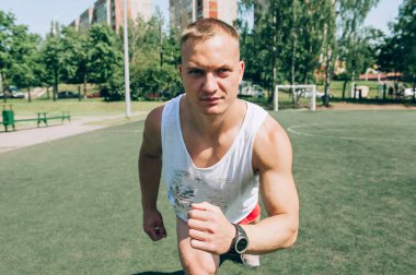 Stadyum arka planında koşan kaslı bir sporcunun fotoğrafı. Tam stadyum planı