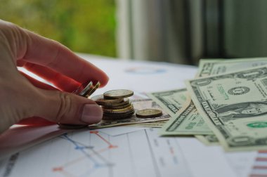 Dolarlar, hesap makinesi, loupe, kalemler ve defterler evrakların üzerinde. Ofis malzemeleri masanın üzerinde. Ofis malzemeleri mali beyanlarda yatıyor. 