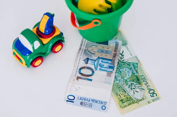 Children\'s toy on the background of Belarusian money. Belarusian ruble money, bills