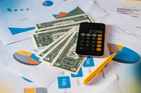 Close up of hands counting money with calculator