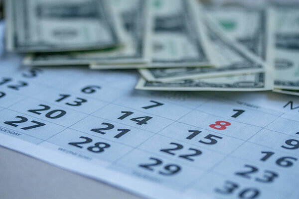 Banknotes of dollars on calendar sheets closeup 