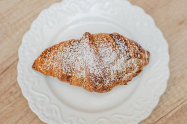 Kahve fincanı ve ahşap arka planda taze pişmiş kruvasan. Üst Görünüm.