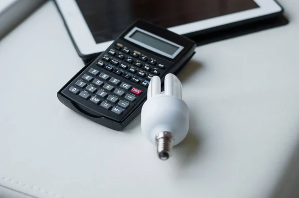 Beyaz arkaplanda enerji verimliliği derecelendirme grafiği, LED ampul ve hesap makinesi, yakın plan