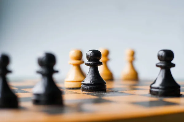 Yüz yüze. Satranç taşları, mavi arka planlı bir satranç tahtasında karşı karşıya. Satranç şövalyeleri karşı karşıya geliyor. Satranç şövalyeleri başa baş.