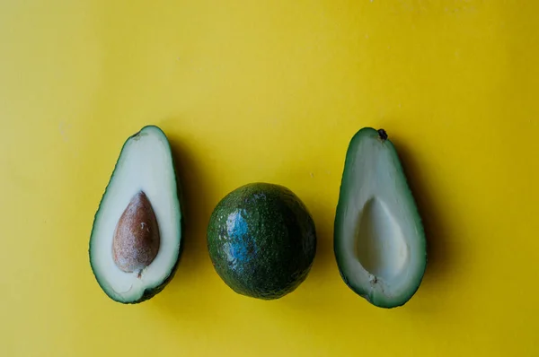 Verse Sla Avocado Een Potje Groene Bladeren Een Gele Achtergrond — Stockfoto