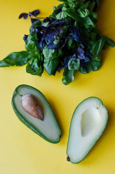 Verse Sla Avocado Een Potje Groene Bladeren Een Gele Achtergrond — Stockfoto
