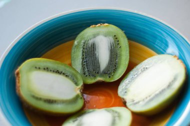 Palmiye yapraklarındaki organik tropikal meyvelerin üst görüntüsü, turuncu ve gri arka planda meyve suyu bulunan greyfurt dilimleri