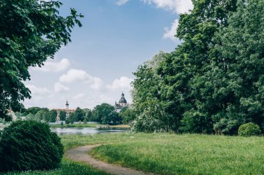 Şehir parkı, çimenli bir çim ve sık bir orman.