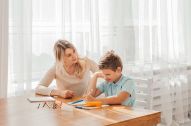 Anne ve çocuk ödev yapıyor.