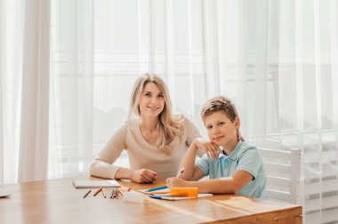 Anne ve çocuk ödev yapıyor.