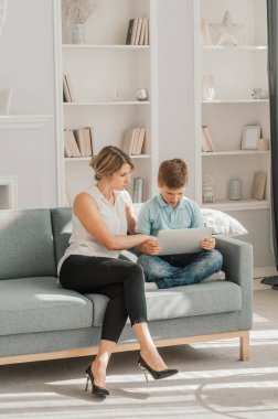 Anne oğluna bakıyor dizüstü bilgisayarda ödev yapıyor