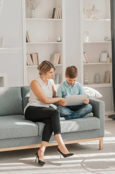 Anne oğluna bakıyor dizüstü bilgisayarda ödev yapıyor