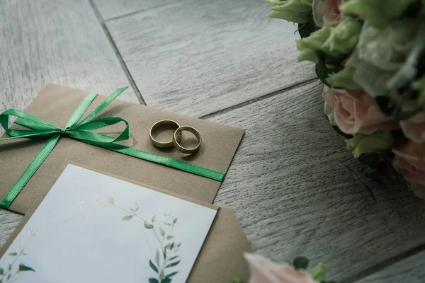 朝のブライダル詳細組成 結婚指輪のトップビュー リボンとピンクの花の美しい花束 — ストック写真