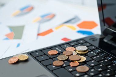 Dizüstü bilgisayarlar, madeni paralar, kağıtlar ve kalem ofiste. 