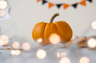 Mum ışığı ve bokeh arkaplanlı Cadılar Bayramı balkabağı. 